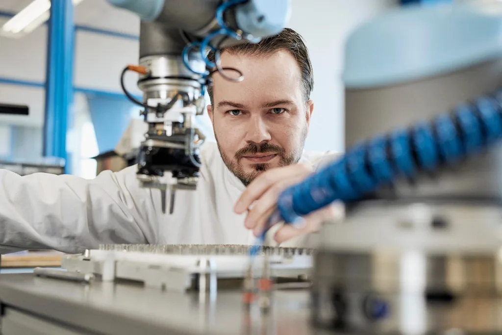 Pinza del cobot che preleva il pezzo per l'asservimento della macchina